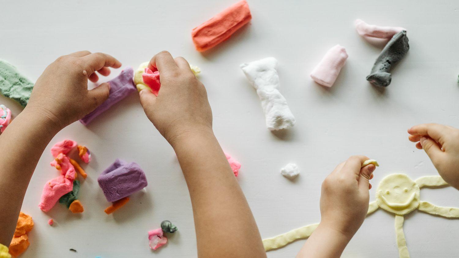 Kids Club Animation Schedule for Ascension, children playing with colored clay.